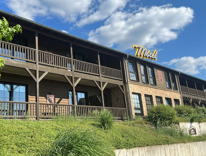 Hotelowy przystanek drogowy Mettmann Dwupiętrowy budynek w stylu zachodnim z drewnianą fasadą i balkonem w Mettmann.