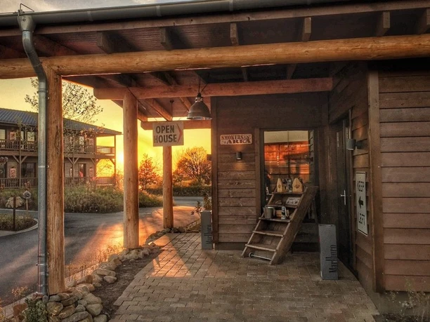 Hotel Road Stop Mettmann o zmierzchu Hotel Road Stop Mettmann o zmierzchu, drewniana fasada i przytulna atmosfera przed wejściem.