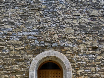 Centre-ville historique Place de l'église de Wülfrath Porte en bois dans une arche médiévale en pierre, entourée de maçonnerie massive et de pavés.