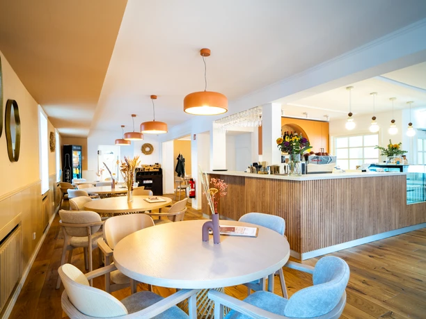 Modern café in Monheim am Rhein, with stylish wooden furniture, warm lighting, and an inviting ambience.