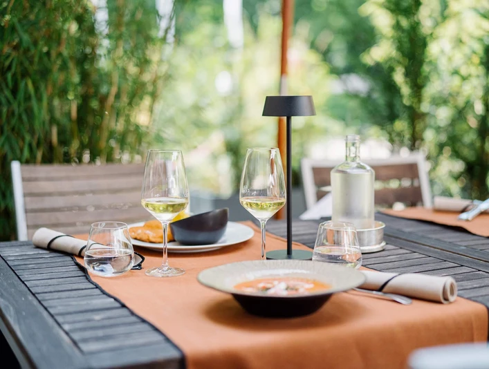 Taras w bistro, Zamek Hugenpoet Stół w Bistro Schloss Hugenpoet z elegancką dekoracją i możliwością spożywania posiłków na świeżym powietrzu.