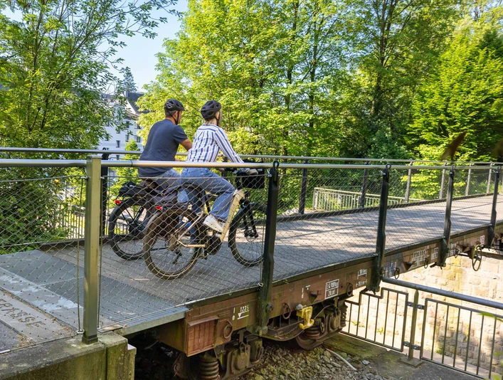 Le pont Waggong à Heiligenhaus Deux personnes portant des casques traversent le pont des wagons à Heiligenhaus avec leurs vélos.