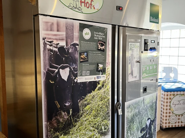 Altenlinderstall farm shop Refrigerators in Spicher's farm shop, decorated with pictures of cows and regional products.