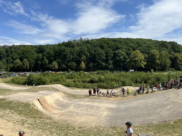 Waldbröl Skate- en Bikepark Mountainbikepark met hellingen en zandheuvels waar bezoekers kunnen rijden, omgeven door bos.