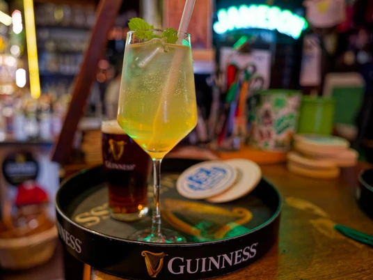 Deliziosi drink al Dingle's Irish Pub a Mettmann Vassoio di Guinness con due birre e long drink decorato in un pub irlandese.