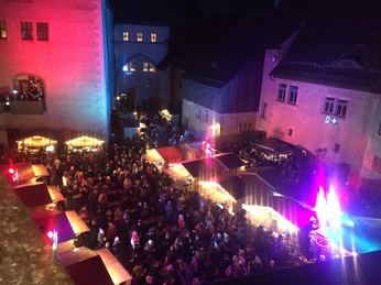Schlossweihnacht in Rochlitz - Weihnachten in der Region Leipzig Der festlich beleuchtete Weihnachtsmarkt im Schlosshof Rochlitz mit zahlreichen Ständen und Besuchern.