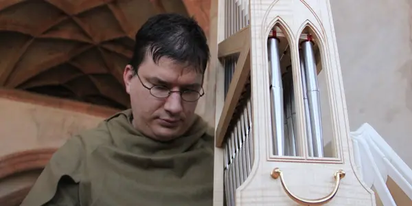 Gästeführer Michael Kreskowsy spielt ein Portativ. Das ist eine kleine Orgel.