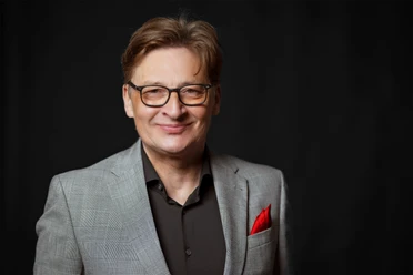 Stefan Verhasselt - "Best of Niederrhein" Portait-Fotografie von Stefan Verhasselt im grauen Anzug vor schwarzem Hintergrund