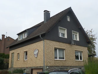 Holiday apartment in Miebach Two-story detached house with dormer window, brick facade and dark gable clad in slate.
