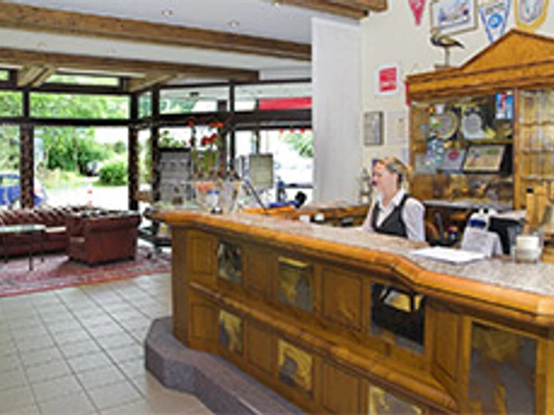 Receptieruimte De hotelreceptie bevindt zich in een uitnodigende foyer met een vriendelijke receptioniste en een comfortabele zithoek.