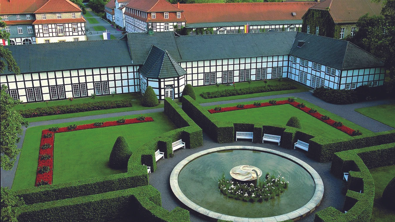Luftaufnahme des Gräflichen Park mit symmetrischen Beeten, Hecken und einem eleganten Springbrunnen.
