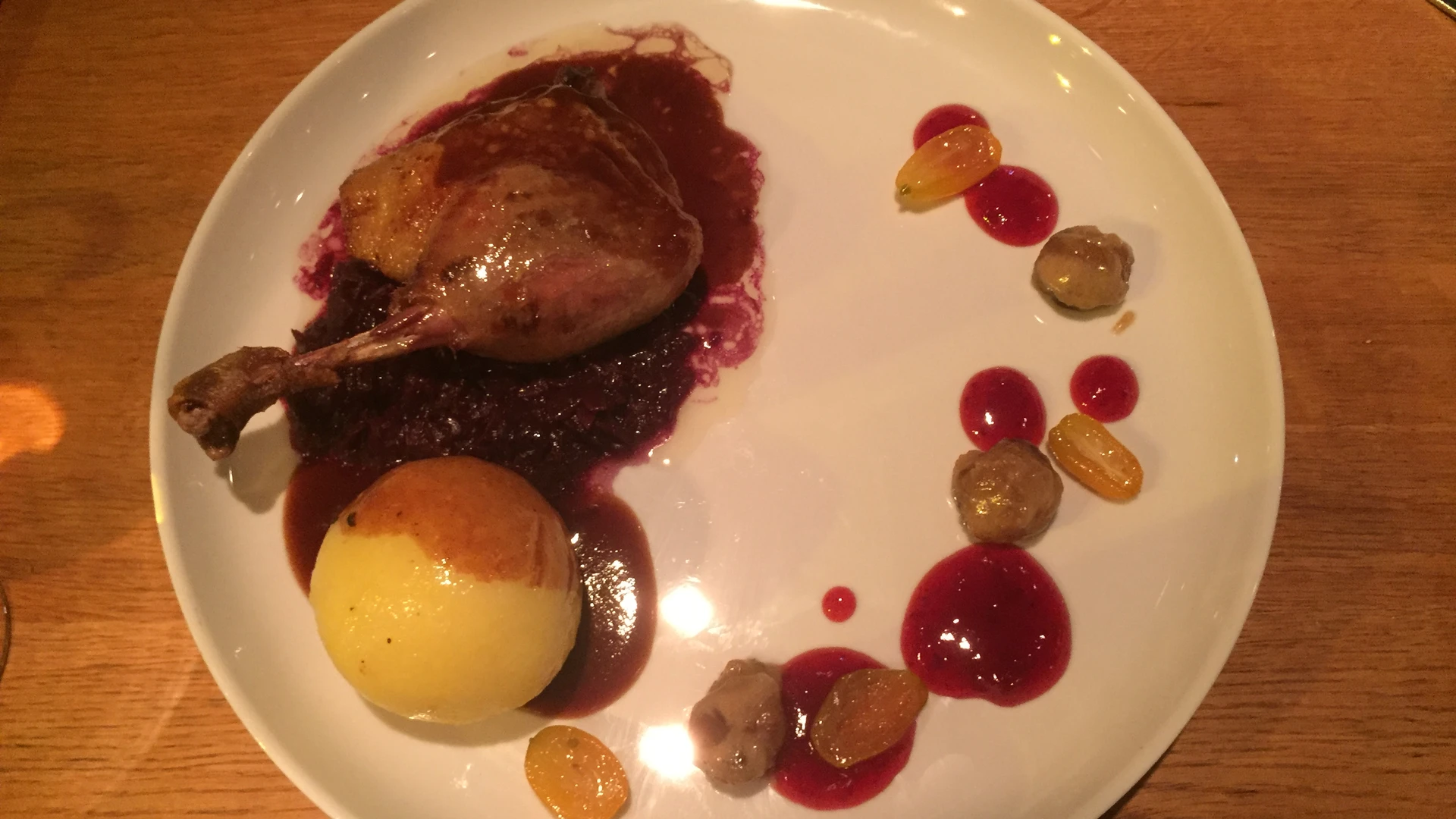 A carefully prepared dish with roasted goose on red cabbage, croquettes and a side sauce.