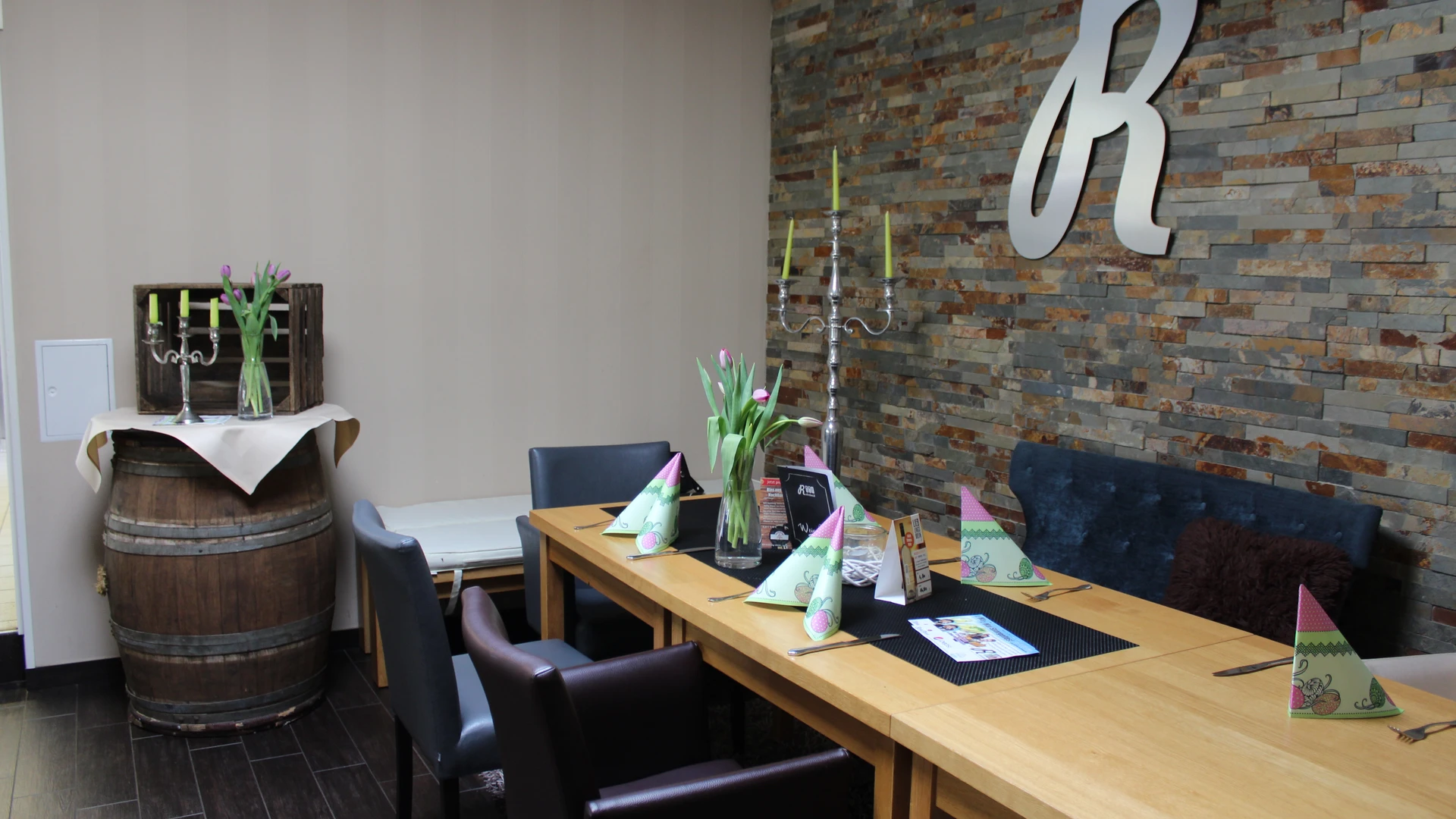 A stylish dining area with tulip flowers and a rustic stone wall in an inn.
