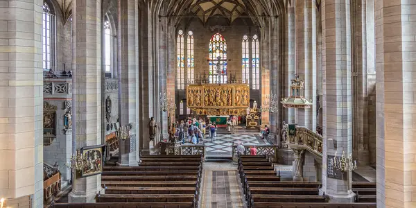 Innenansicht des Zwickauer Doms mit gotischen Arkaden und einem geschnitzten Altar.