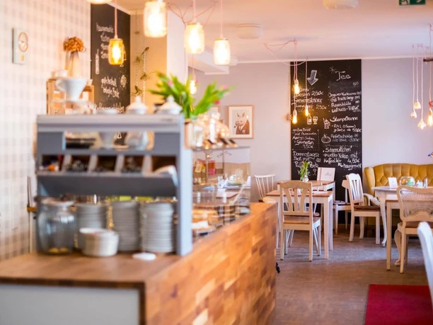 Acogedora cafetería con muebles de madera e iluminación cálida, un lugar que invita a una reunión relajada.