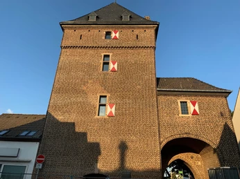 Torre del burlone a Monheim am Rhein Schelmenturm, una torre medievale in mattoni a Monheim am Rhein, con decorazioni rosse e bianche.